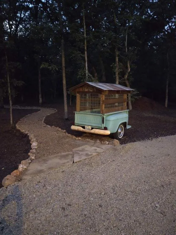 Vintage truck converted to chicken coop at dusk