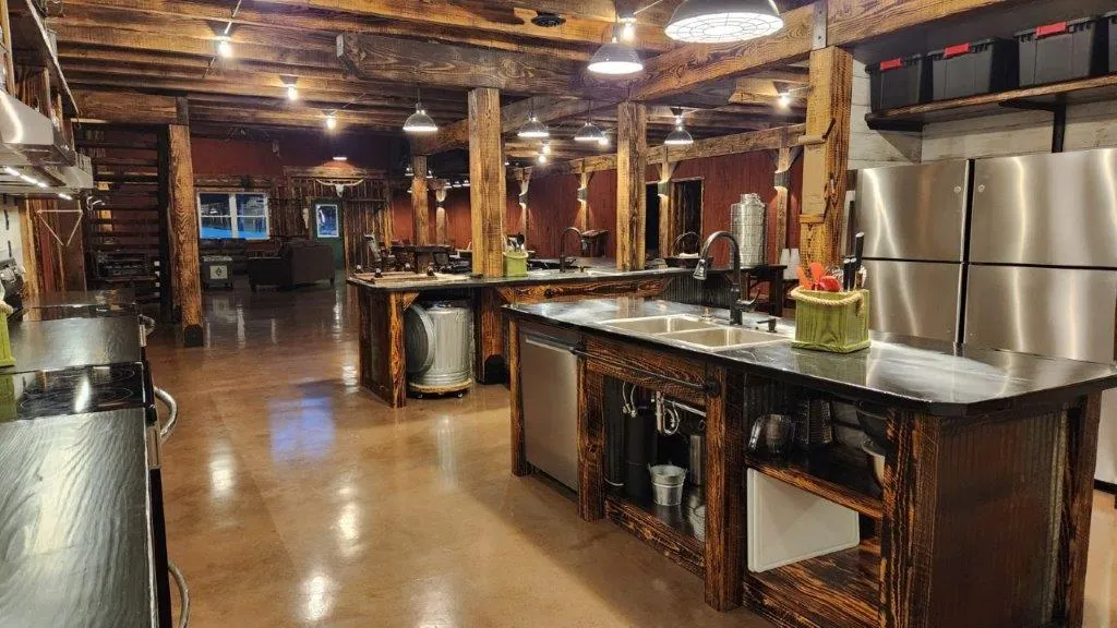 Full kitchen with prep island, sinks, and stainless fridge