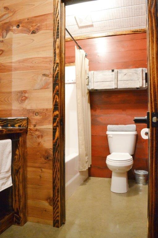 Shared bathroom with wood-plank walls