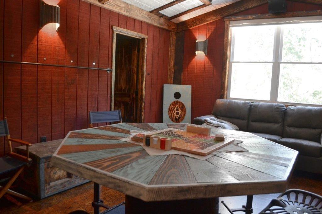 Octagonal game table with sofa and cornhole