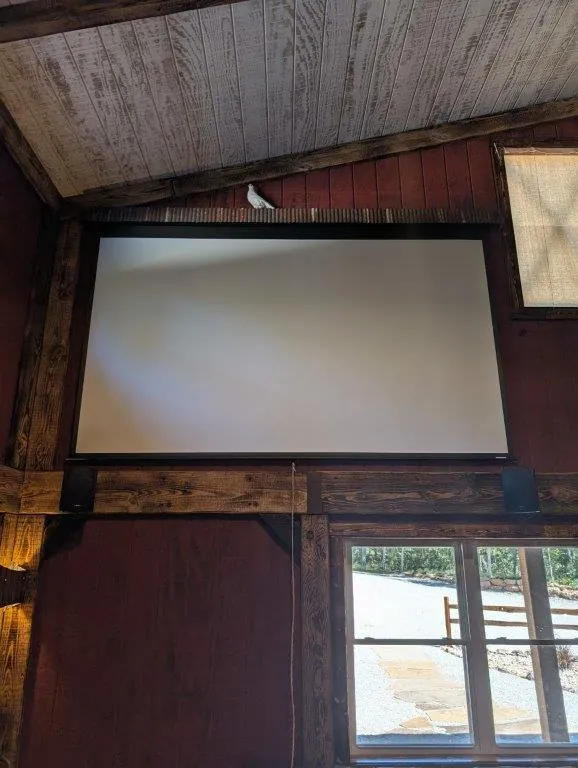 Built-in projector screen mounted on barn-red wall